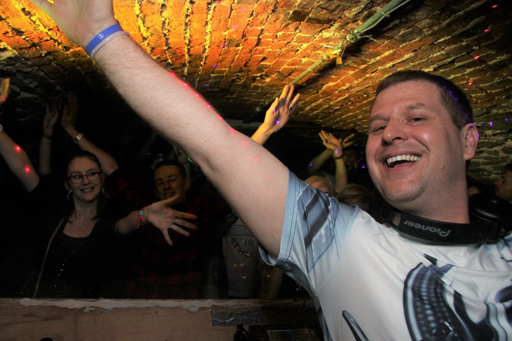 DJ with arms raised and crowd behind at Trancelation