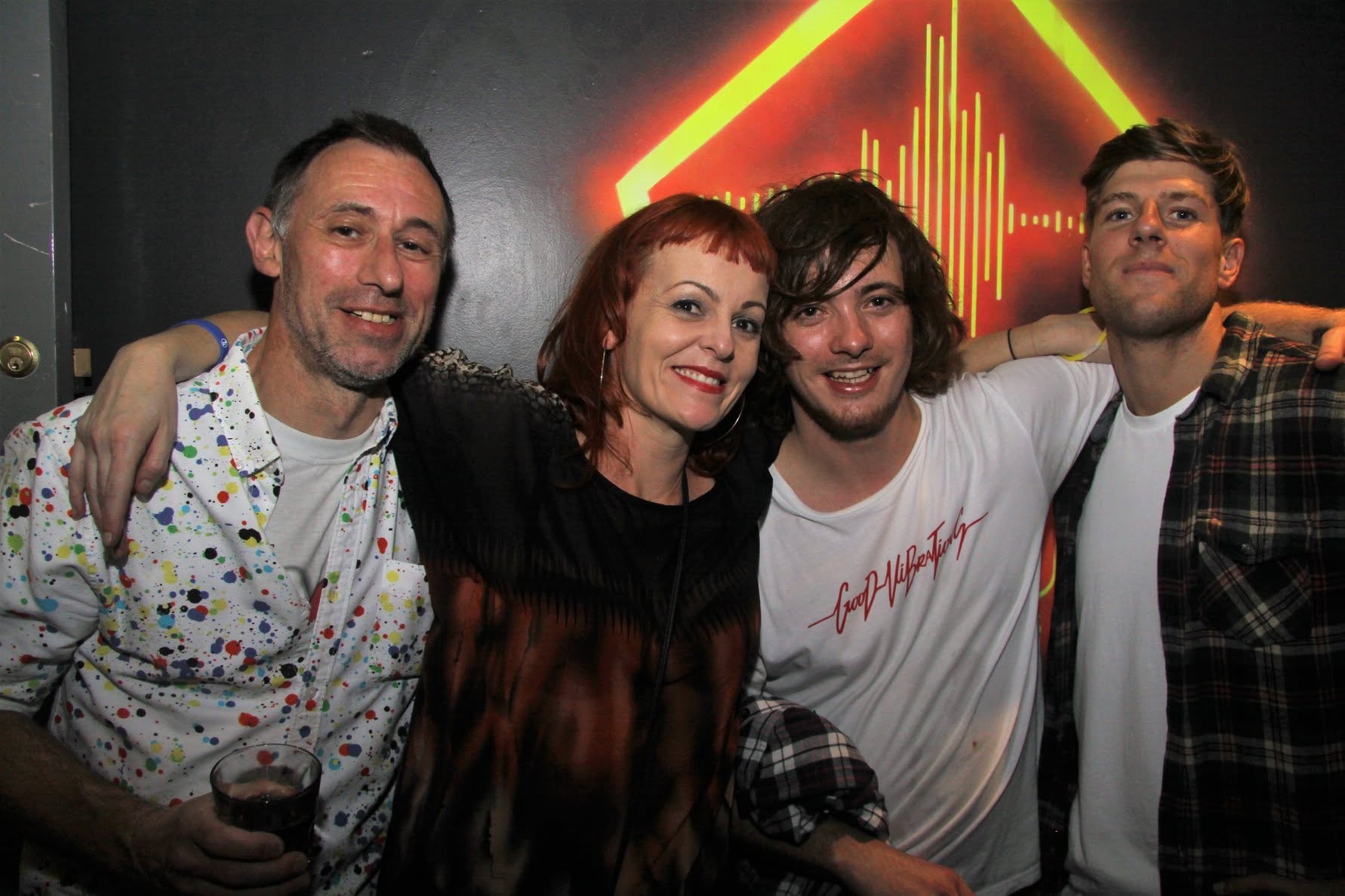 Group of four in front of neon sign at Trancelation