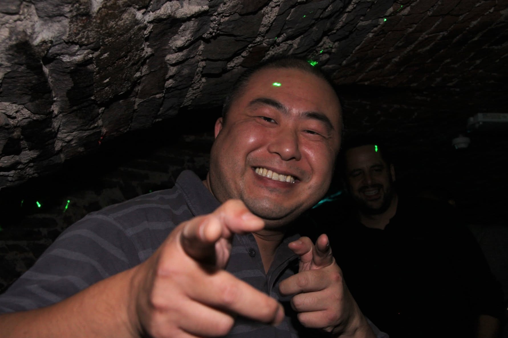 Crowd member pointing at the camera under lasers