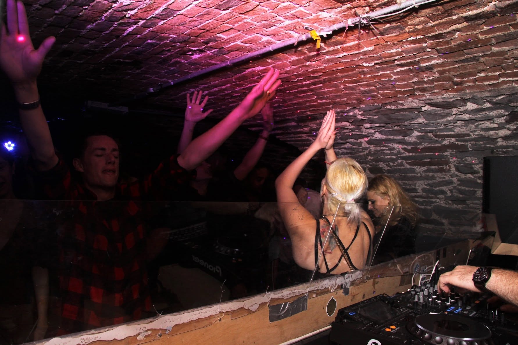 Female DJ with hands raised and crowd behind at Trancelation