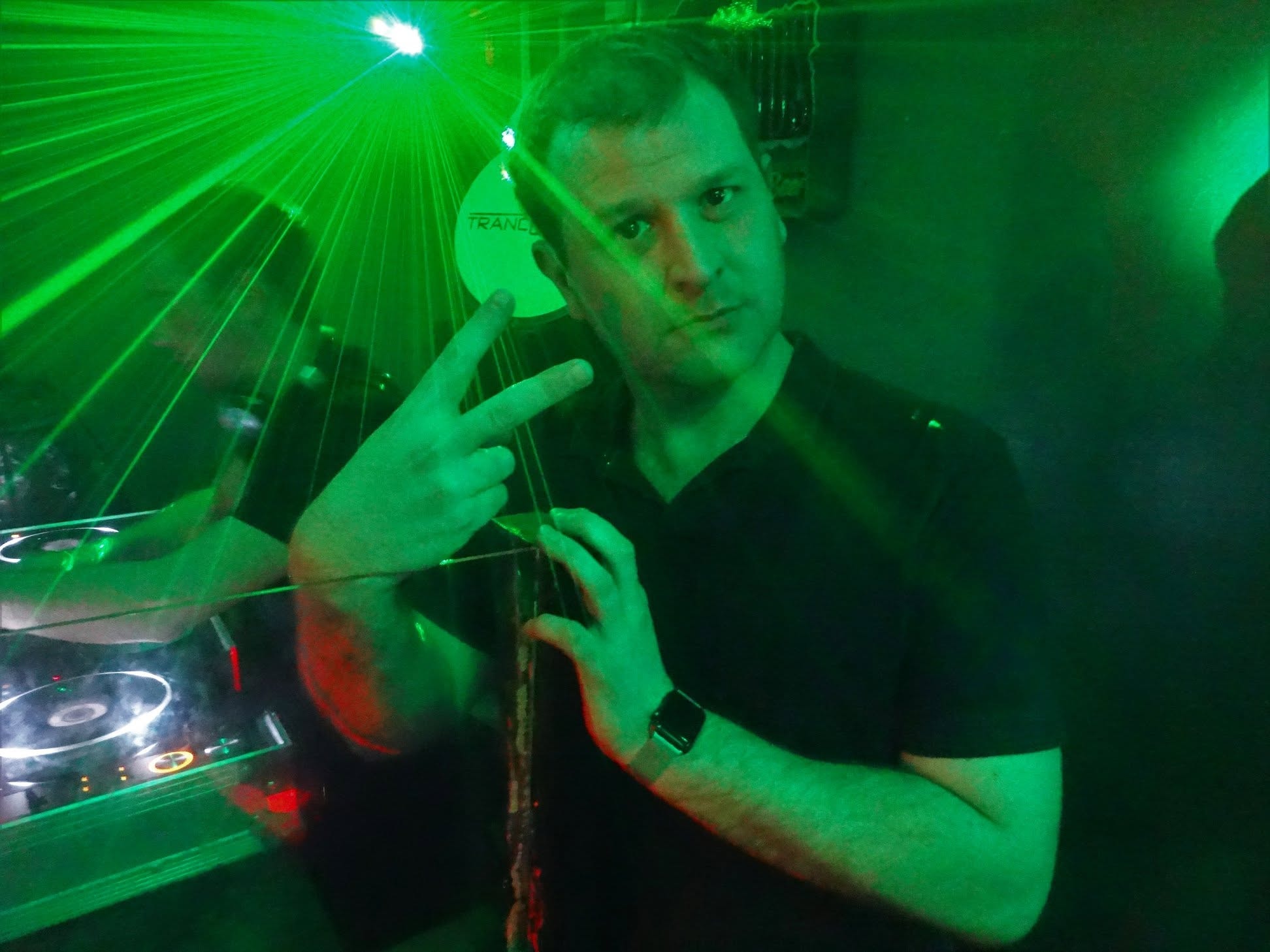 Two DJs mixing together under green and red lasers, Trancelation banner behind
